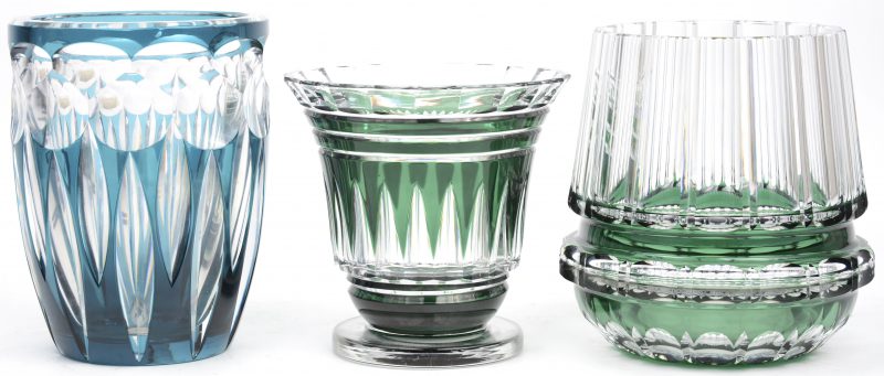 Drie groene vazen van geslepen kristal. Eén met een hoge, rechte rand (H. 18 cm), één kratervaasje meet voetstuk en onderaan gemerkt Val Saint-Lambert (H. 15 cm) en een blauwachtige groene vaas (H. 18 cm).