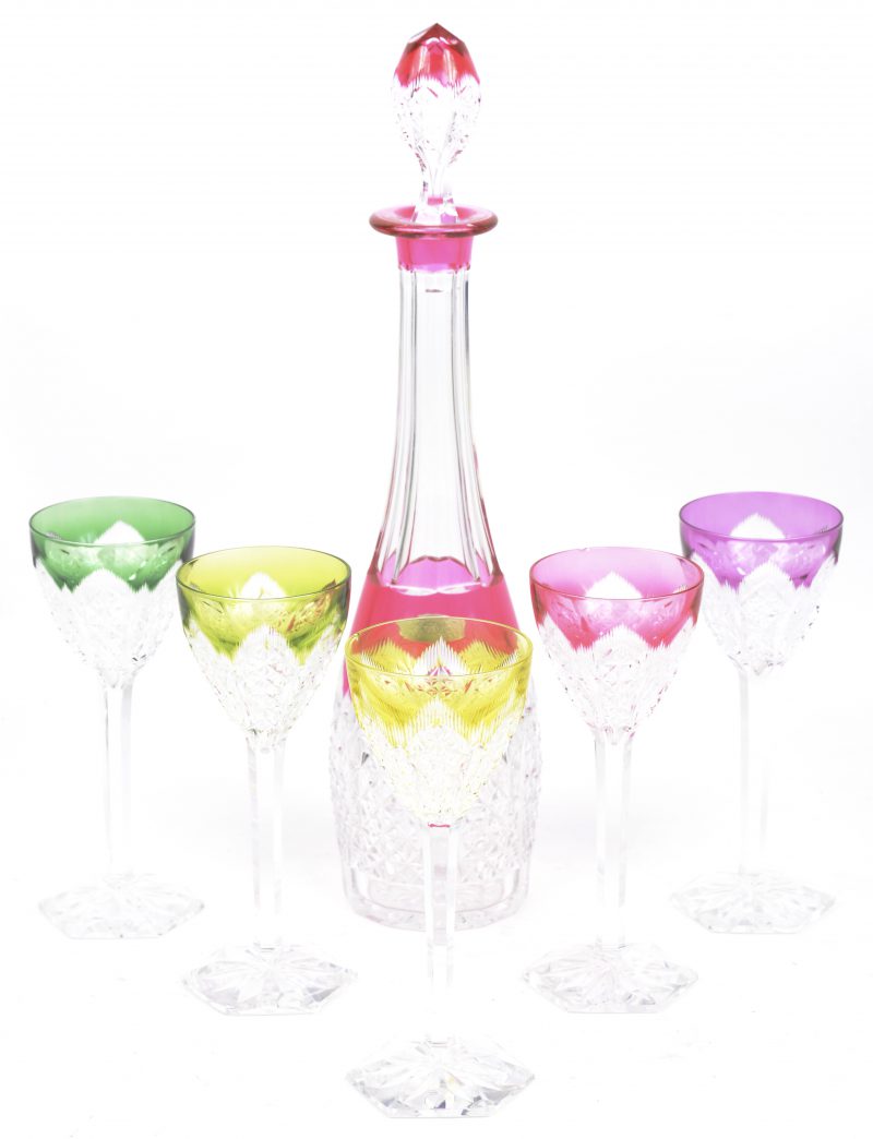 Een langwerpige kristallen karaf en vijf dito hoogstammige wijnglazen in diverse kleuren. De karaf gemerkt met label.