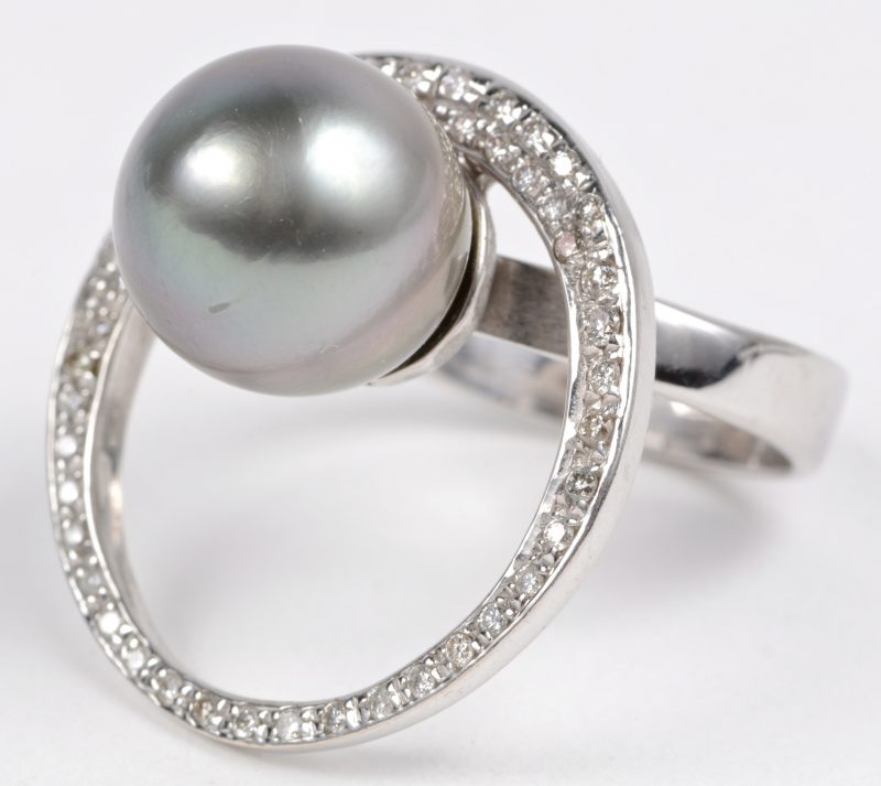 Een 18 karaats wit gouden ring bezet met diamanten met een gezamenlijk gewicht van ± 0,70 ct. en een grijze Tahiti parel.
