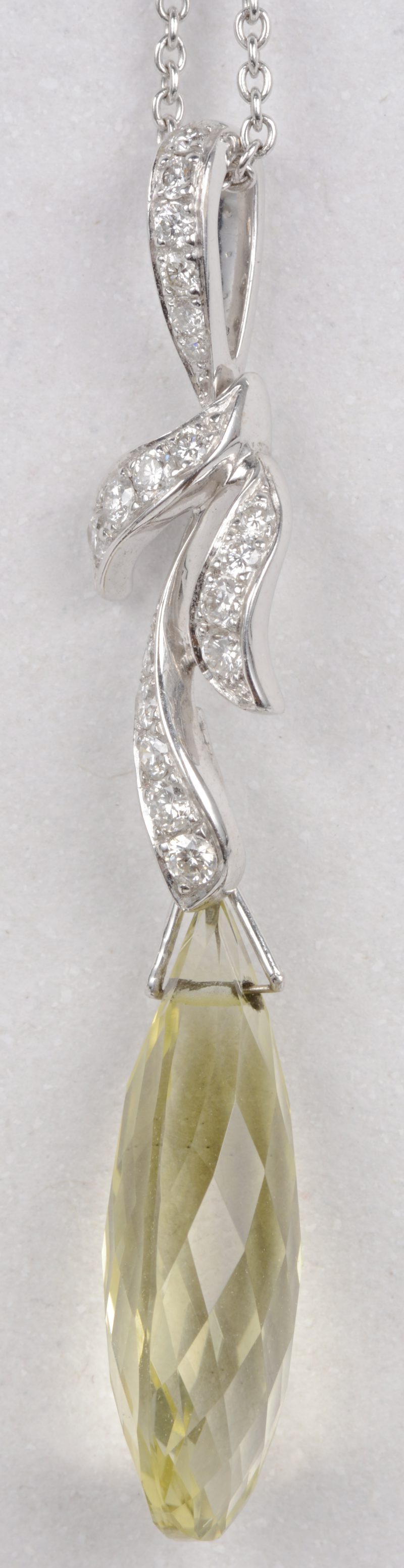Een 18 karaats wit gouden ketting met een in briolette geslepen hanger van peridot en briljanten met een gezamenlijk gewicht van ± 0,30 ct.