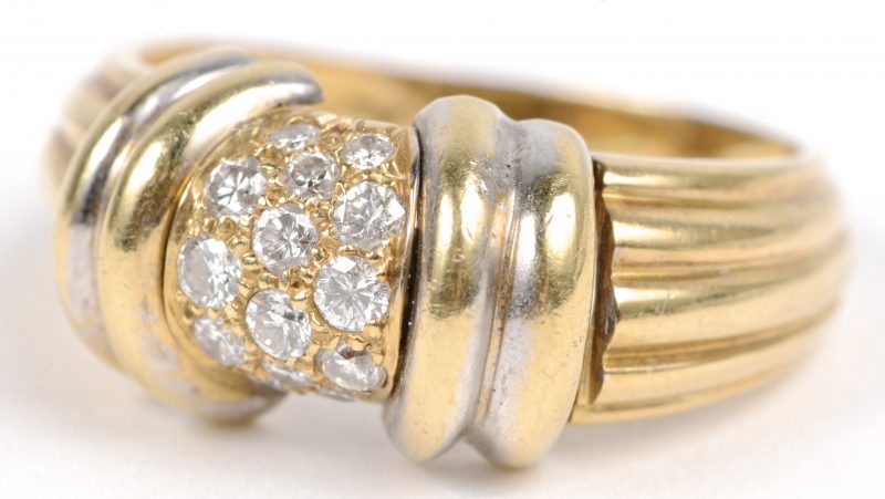 Een 18 karaats wit en geel gouden ring bezet met briljanten met een gezamenlijk gewicht van ± 0,30 ct.