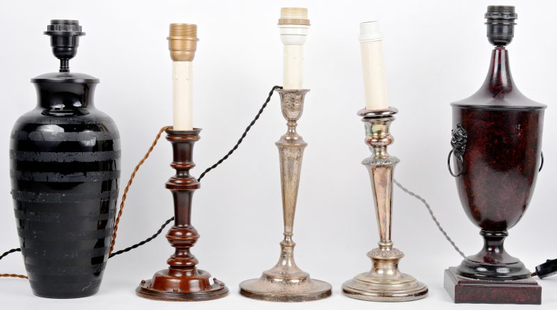Een lot van vijf verschillende lampenvoeten, waarbij twee van verzilverd metaal, een houten, een zwart glazen en één van beschilderd metaal in marmerimitatie.