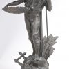 Een paar schemerlampen met kappen in de geest van Tiffany’s gemonteerd op metalen figuren van een jongen en een meisje (één met letsel bovenaan).