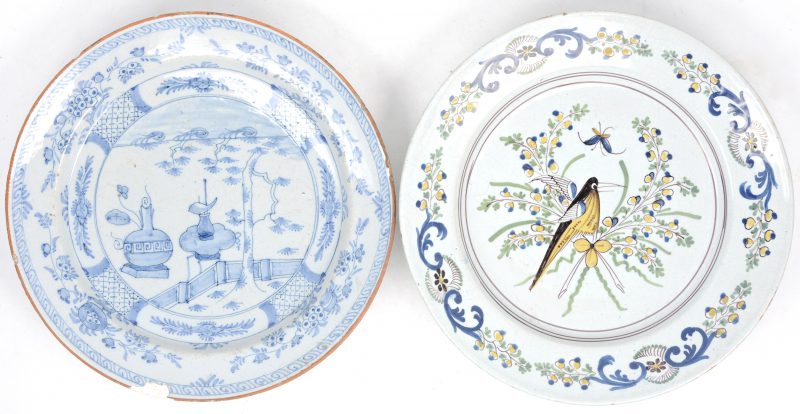 Twee XVIIIe eeuwse aardewerken schotels, waarbij een Franse met een vogel in het plat en een Delftse met Chinees decor. De tweede gemerkt en met randschilfer.