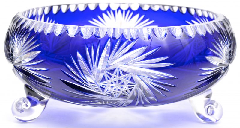 Een coupe van geslepen blauw Boheems kristal op drie voetjes.
