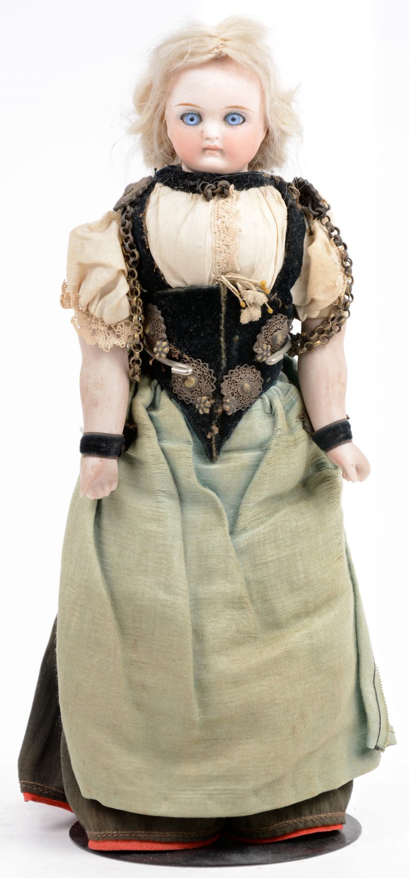 Antieke pop met schouderplaathoofdje. Lijfje van textiel, met porseleinen onderarmen. Originele klederdracht (Zeeuws?).
