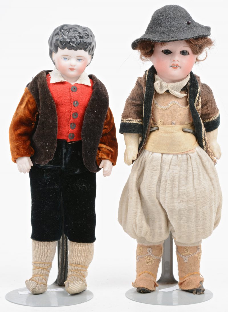 Een paar antieke popjes met biscuit hoofden en blauwe geverfde ogen. Lijf van textiel met porseleinen handen. Originele kleding (Duits?).