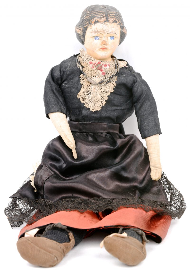 Een antieke pop met papier mâché hoofd met schouders. Oude klederdracht. XIXde eeuw. Zonder merken.