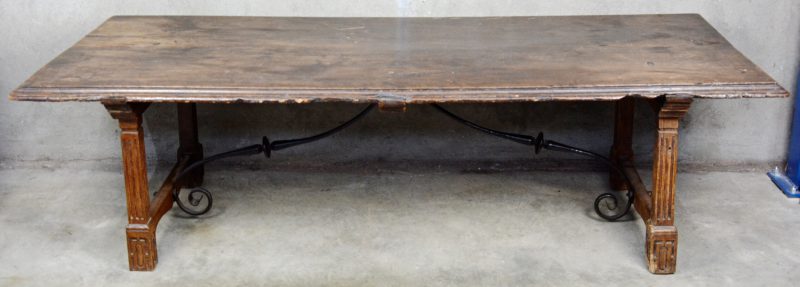 Een antieke salontafel met gerainureerde poten met smeedijzeren verbinding.