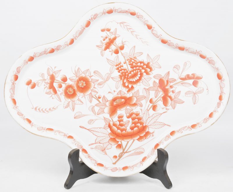 Een gelobde schotel van Japans porselein met een roestrood decor van bloemen.