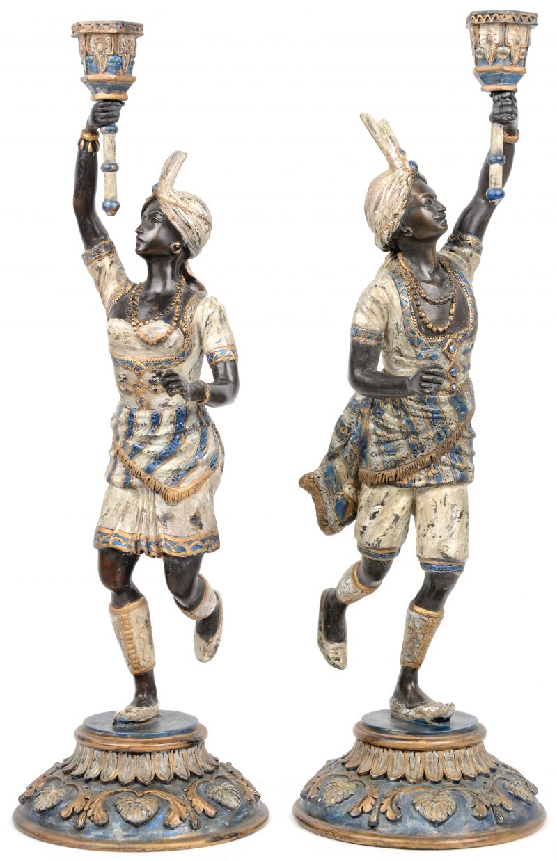 Een paar kandelaars van gepatineerd brons, de kaarsenhouders gedragen door een Oriëntaals paar.