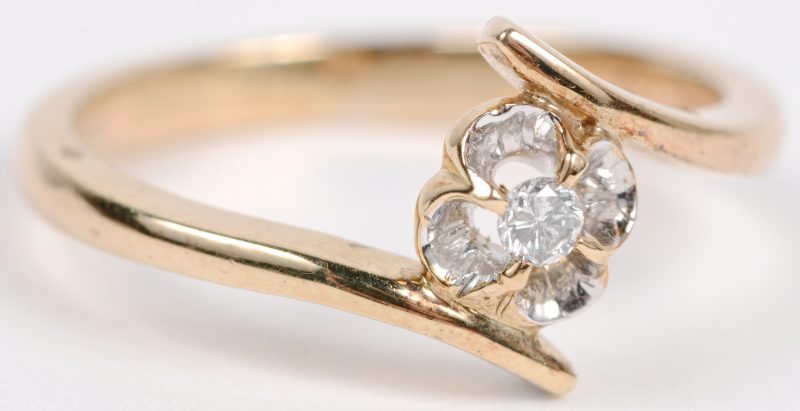 Een 14 karaats geel gouden bloemvormige ring bezet met diamanten met een gezamenlijk gewicht van ± 0,05 ct.