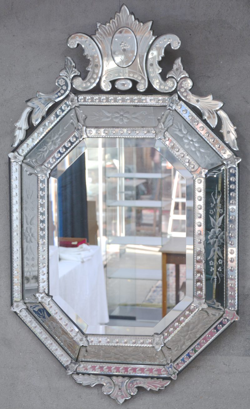 Een Venetiaanse spiegel van geslepen en gegraveerd glas.