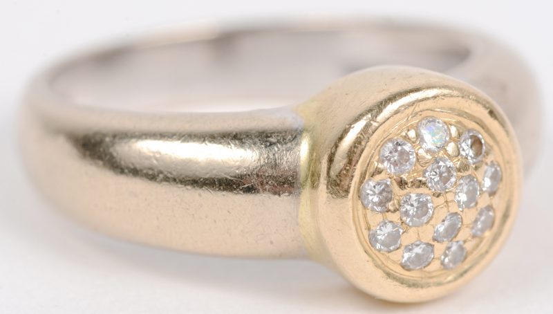 Een 18 karaats wit en geel gouden ring bezet met briljanten met een gezamenlijk gewicht van ± 0,20 ct.