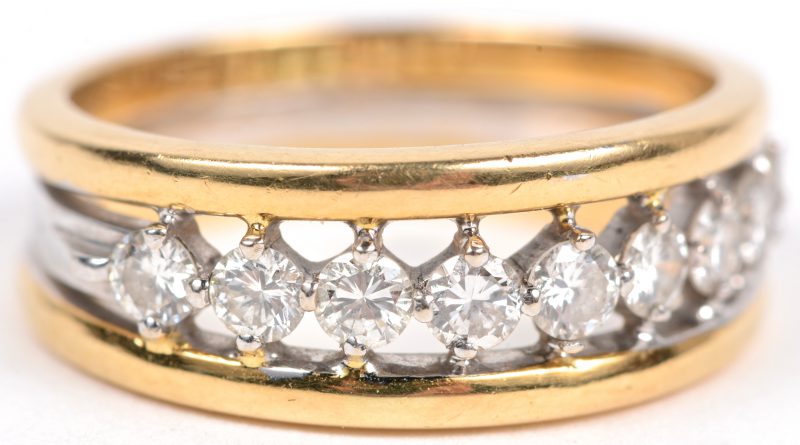 Een 18 karaats wit en geel gouden ring bezet met briljanten met een gezamenlijk gewicht van ± 0,55 ct.