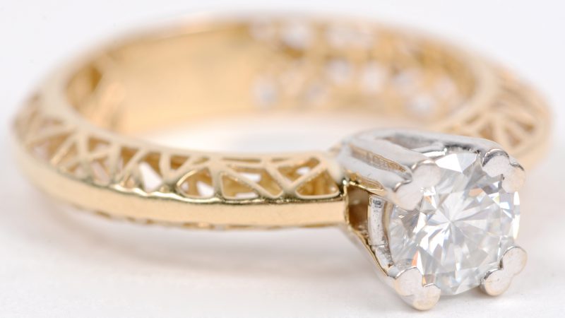 Een 18 karaats wit en geel gouden ring bezet met een solitair van ± 0,70 ct.