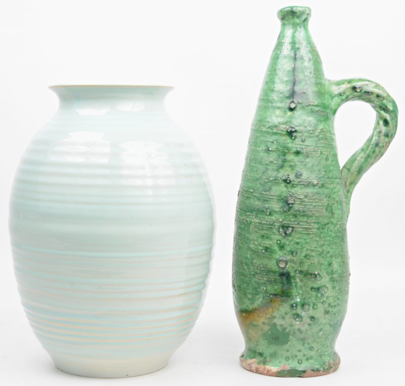 Een aardewerken vaas met lichtblauw glazuur en een kruik met groen glazuur. Beide onderaan gemonogrameerd ‘P.G’.
