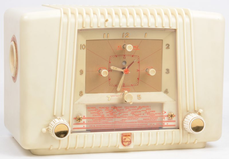 Een oude wekkerradio in wit kunststoffen kast. 1953.