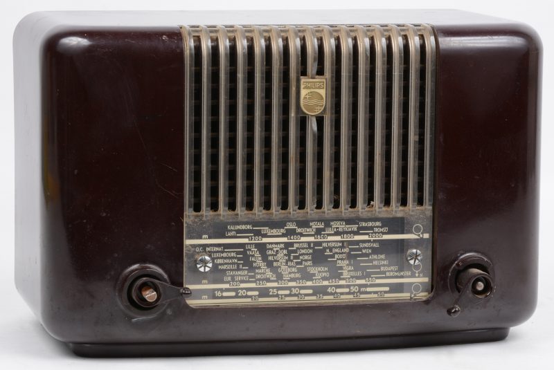 Een oude bakelieten klokradio. Type BX332A. Bouwjaar 1953. Draaiknopjes manco.