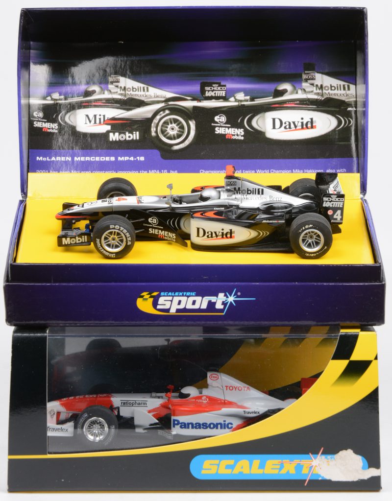 “McLaren Mercedes F1 MP4-16 No.16” & “Toyota F1 2002 No.25”. Twee schaalmodellen voor een ‘Sport digital’ racebaan. De eerste gelimiteerd op 5000 exemplaren. In originele doosjes.