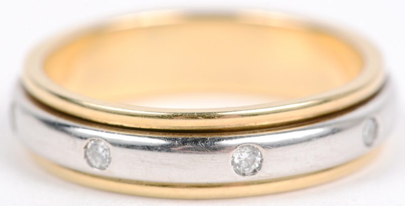 Een 18 karaats wit en geel gouden ring bezet met een briljanten met een gezamenlijk gewicht van ± 0,16 ct. Model Piaget.