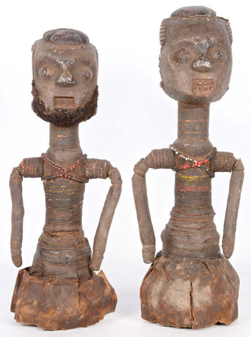 Een paar Afrikaanse voorouderbeelden, afgewerkt met textiel, haar en kralen.