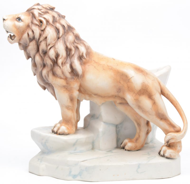 Een siervaas van meerkleurig porselein in de vorm van een leeuw op een rots. Mogelijk Amphora.