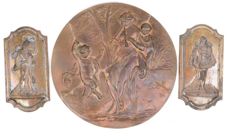 Een lot van drie bronzen plaquettes met reliëfdecors. De 2 kleine met personages uit de XVIIde eeuw. De grootste met Diana en dansende faunen naar Boucher, gerestaureerd.