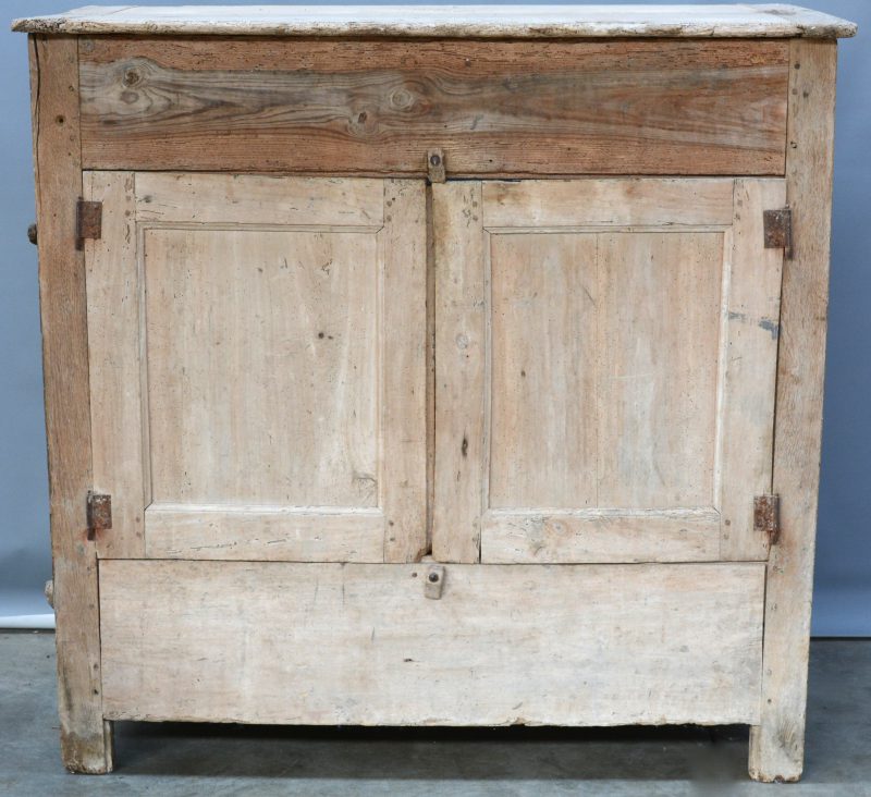 Een antiek houten meubel met twee paneeldeuren en een uitneembaar zijpaneel.