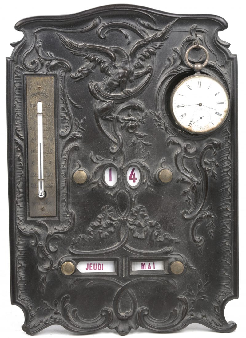 Een gesculpteerde ebbenhouten bureaukalender versierd met een drakenmotief, voorzien van een kalender, een thermometer en een zakhorloge (slijtage) aan een haakje. Begin XXste eeuw.
