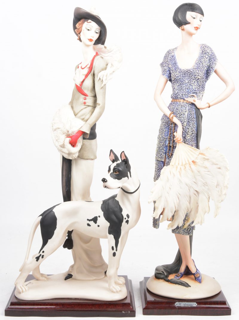 “Dame met hond” & “Dame met waaier’. Twee beelden van meerkleurig kunststof naar ontwerp van Guiseppe Armani. Gemerkt en gedateerd 1987.