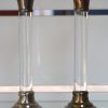 Twee geslepen glazen karaffen en een kristallen snavelkan met verzilverde monturen, bijgevoegd twee glazen kandelars met metalen monturen.
