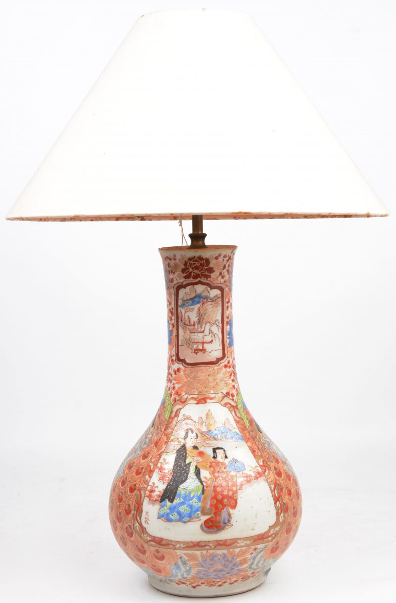 Een Imari vaas met lange hals, veelkleurig decor met personages in uitsparingen. Schade aan de hals en gemonteerd als lamp. XIXde eeuw.