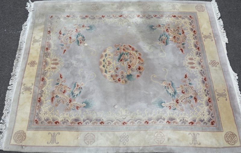 Een Chinees wollen tapijt met een decor van draken. Te reinigen.