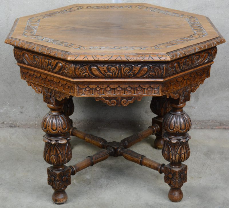 Een achthoekige salontafel van gebeeldhouwd eikenhout in barokke stijl met balusterpoten.