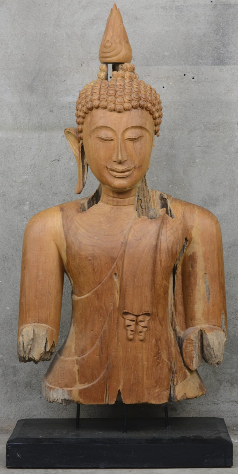 Een gebeeldhouwde Thaise Boeddha van verweerd hout.