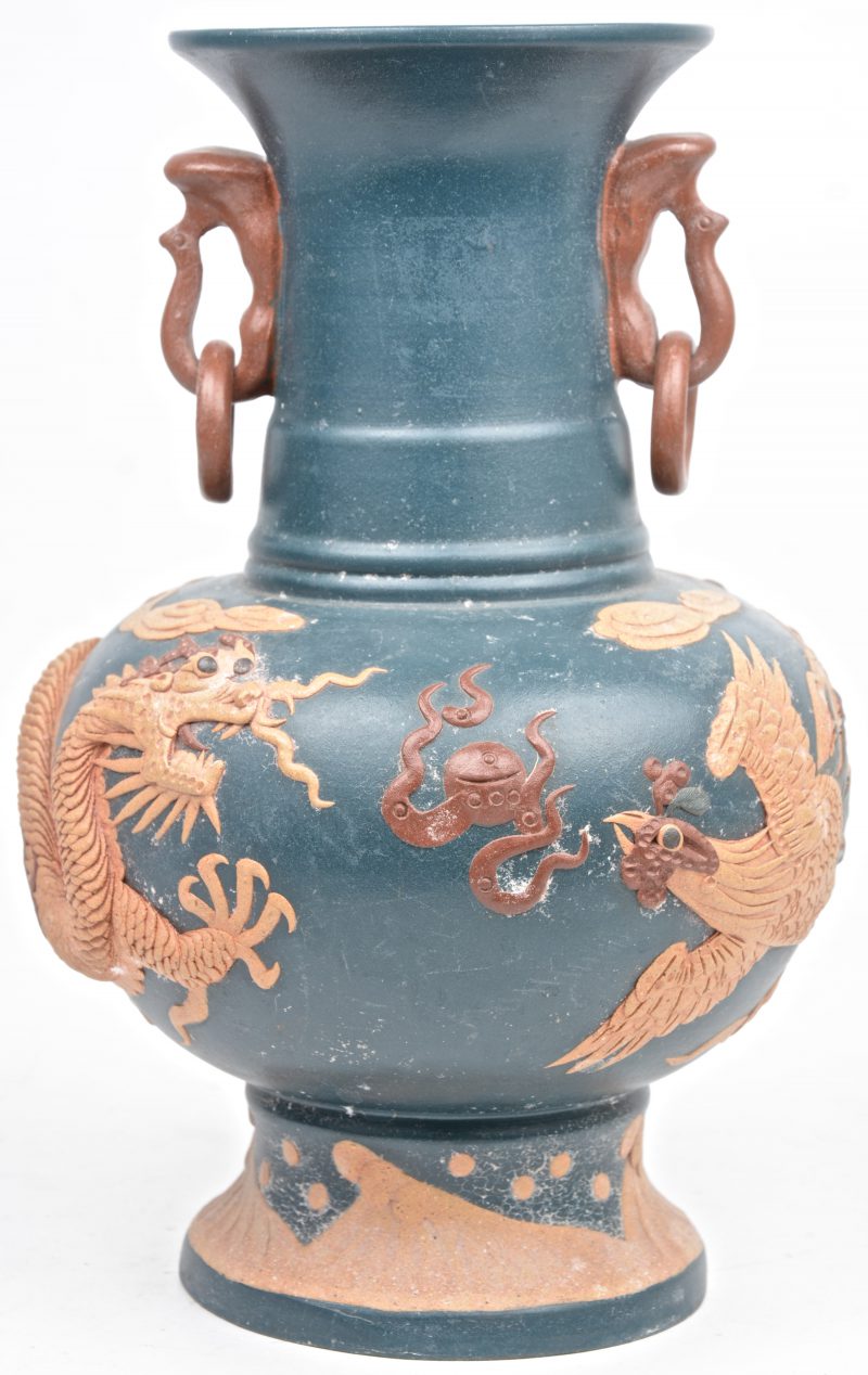 Een aardewerk van Chinees steengoed, versierd met een decor van een draak en een pauw in reliëf. Onderaan gemerkt.