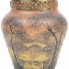 Een pique-fleurs van met een landschap beschilderd glas, gesigneerd P. Jost, met koperen montuur, een laag vaasje in de geest van Loetz, een monochrome amberkleurige art deco vaas van gegoten glas.