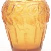 Een pique-fleurs van met een landschap beschilderd glas, gesigneerd P. Jost, met koperen montuur, een laag vaasje in de geest van Loetz, een monochrome amberkleurige art deco vaas van gegoten glas.