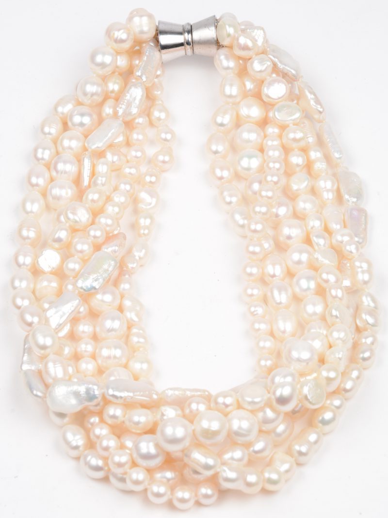 Een halsketting met zes rijen verschillende witte zoetwaterparels.