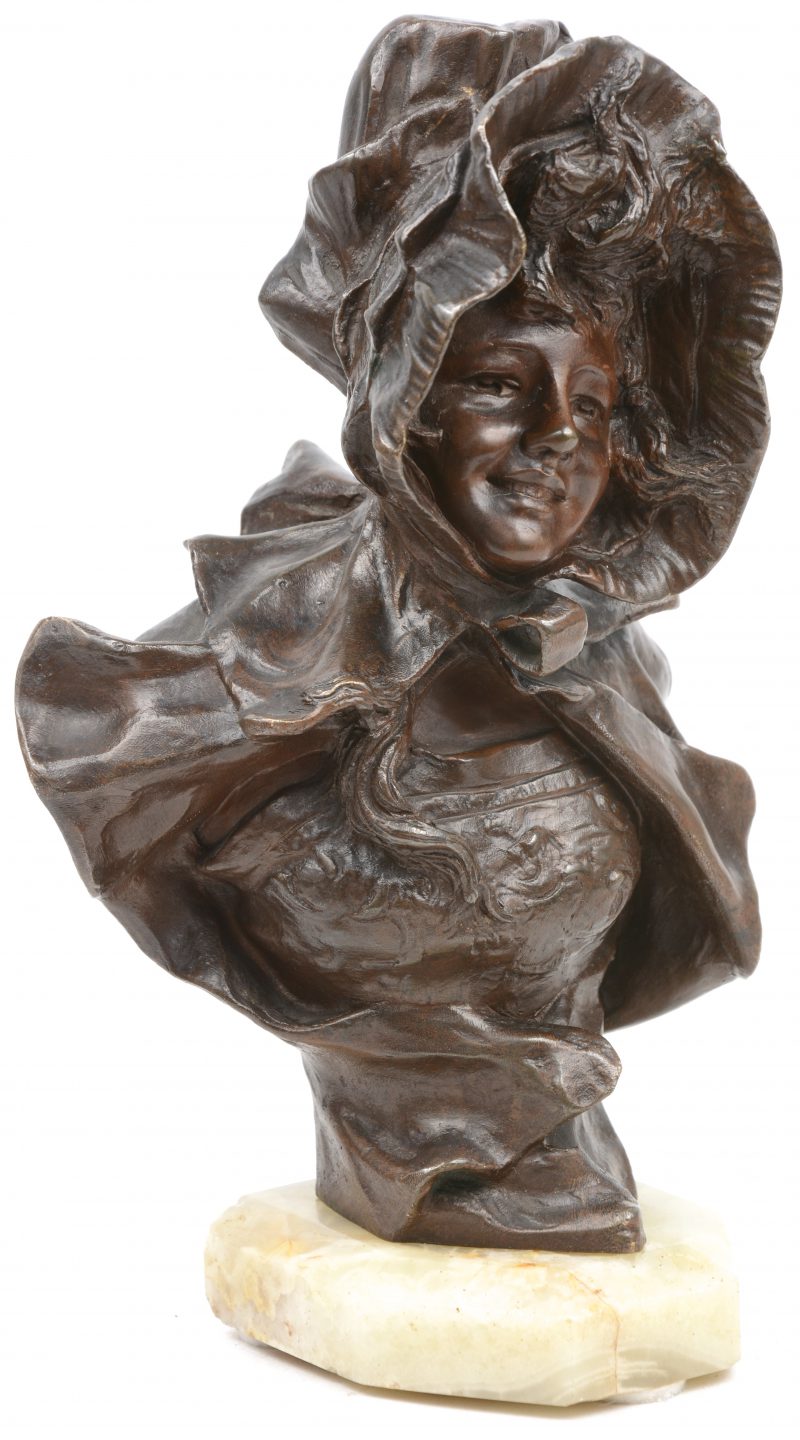 “Meisje met kapmantel”. Een bronzen buste. Gesigneerd en met stempe van de ‘Société des Bronzes de Paris’.