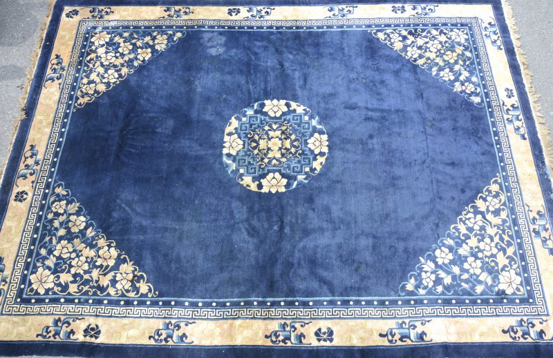 Een antiek Chinees wollen tapijt. Slijtage.