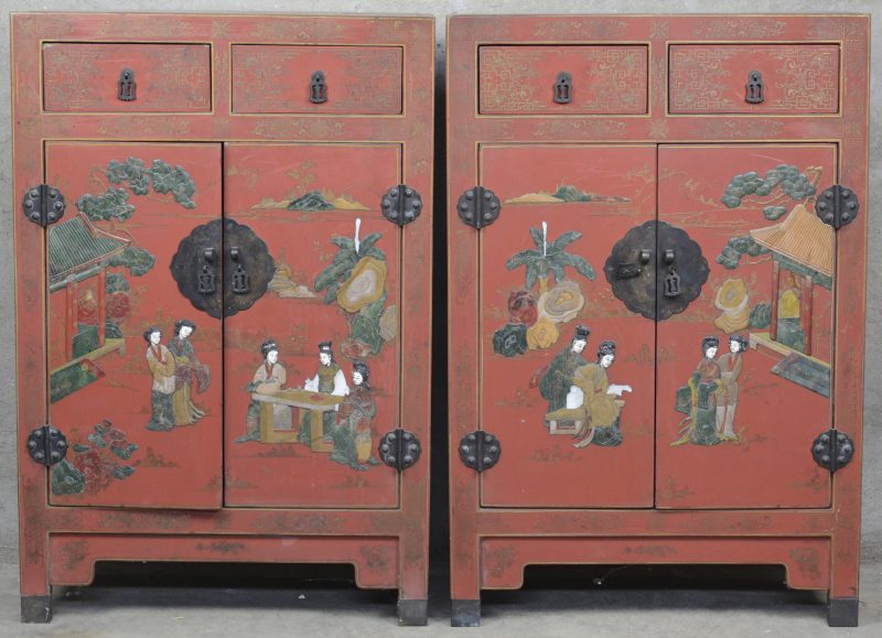 Een paar roodgelakte Chinese kastjes met twee deuren en twee laden, versierd met pietra dura taferelen van Geisha’s in een tuin op het  front en bloemen en vogels op de flanken.