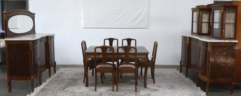 Een gefineerde notenhouten eetkamer, bestaande uit een tafel met zes stoelen en twee buffetkasten met marmeren blad, waarbij één met spiegel en één met opzet met spiegel en glazenkastjes.