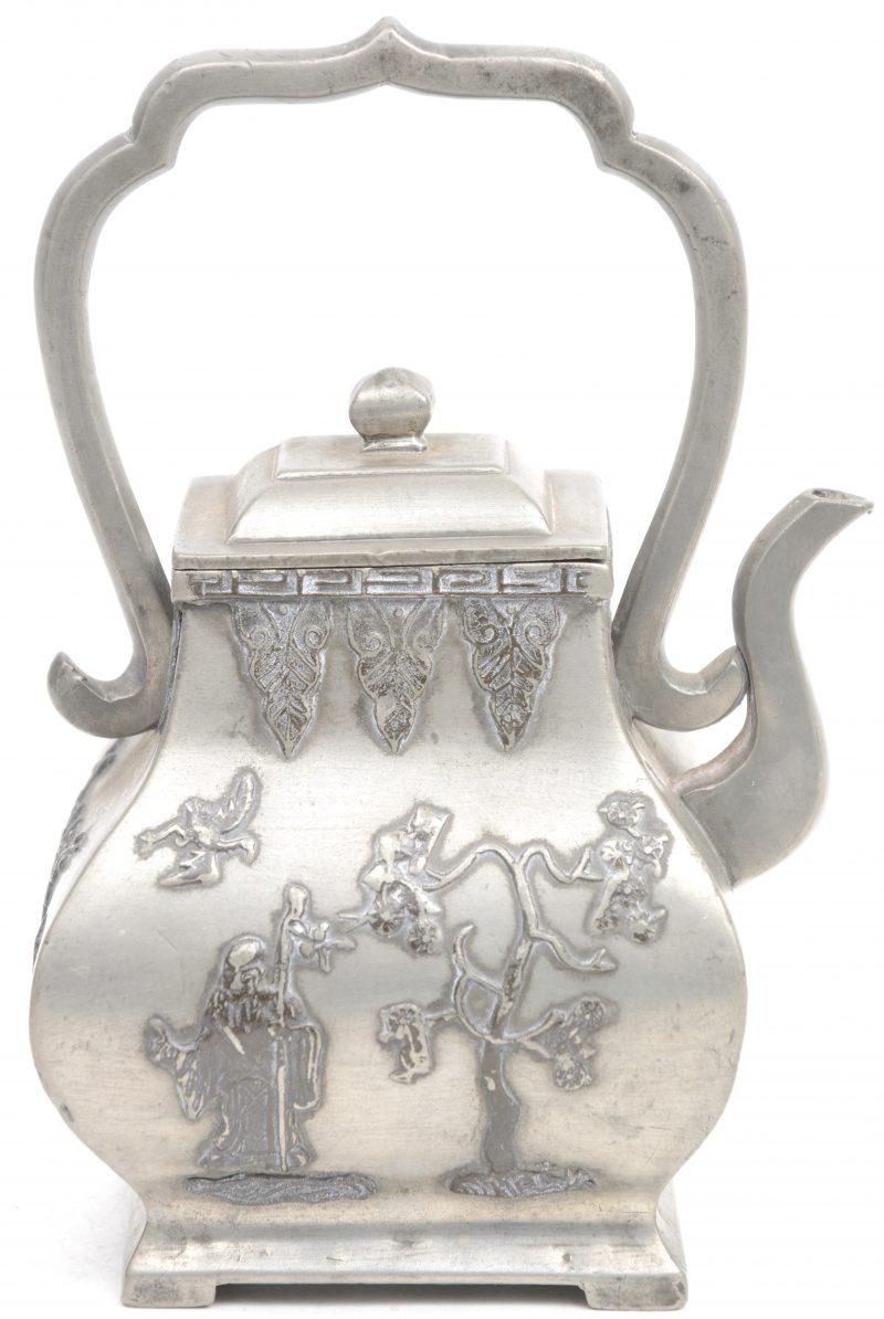Een klein metalen theepotje, versierd met tekens en bloesems in reliëf. Onderaan gemerkt.