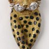 Een 18 karaats wit en geel gouden set waaronder een broche, armband, ring, oorbellen en ketting met hanger in de vorm van panters bezet met briljanten met een gezamenlijk gewicht van ± 0,40 ct. en onyx