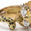 Een 18 karaats wit en geel gouden set waaronder een broche, armband, ring, oorbellen en ketting met hanger in de vorm van panters bezet met briljanten met een gezamenlijk gewicht van ± 0,40 ct. en onyx