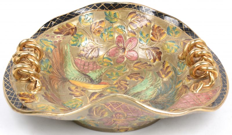 Een sierschotel van Belgisch aardewerk met een meerkleurig en verguld decor van vogels en bloemen.