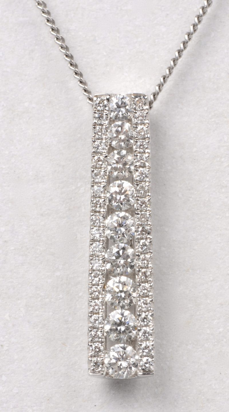 Een 18 karaats wit gouden ketting met hanger bezet met briljanten met een gezamenlijk gewicht van ± 0,56 ct.
