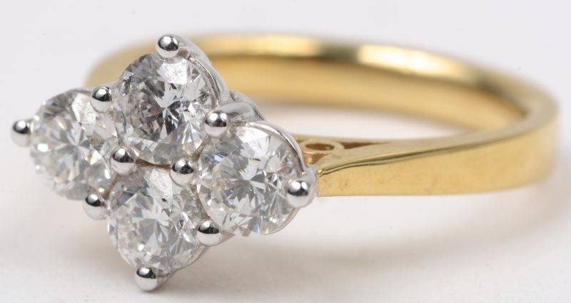 Een 18 karaats wit en geel gouden ring bezet met vier diamanten met een gezamenlijk gewicht van ± 1,50 ct.